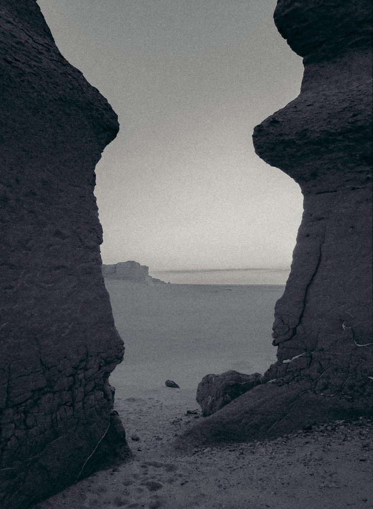 Desert landscape seen through a gap between two rock formations, Sahara
